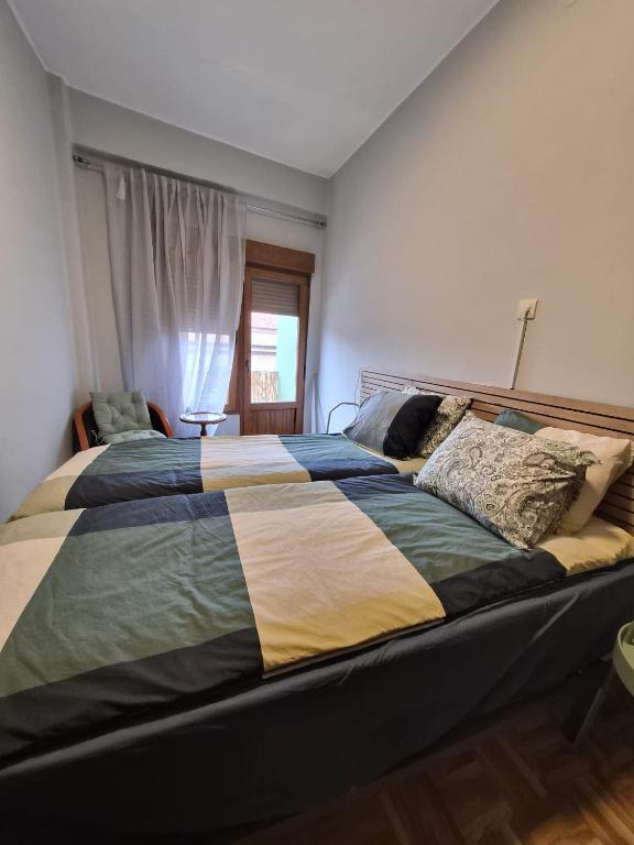 a bedroom with a large bed with a striped comforter at Espacio Yina Grado in Grado