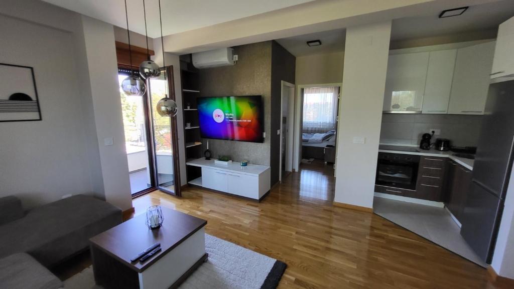 a living room with a couch and a tv on the wall at SiM Lux in Čačak