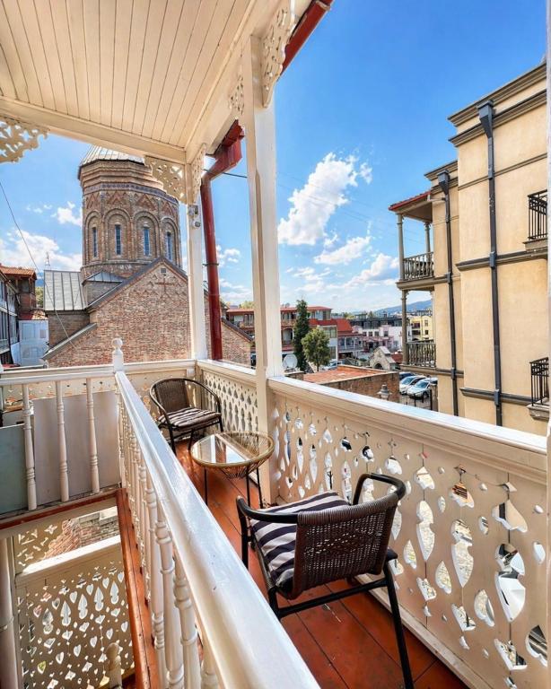 a balcony with chairs and a view of a church at Vernisa Hotel in Tbilisi City