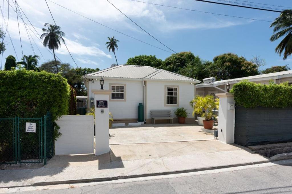 a white house with a parking meter in front of it at The Little White Cottage in Saint Peter