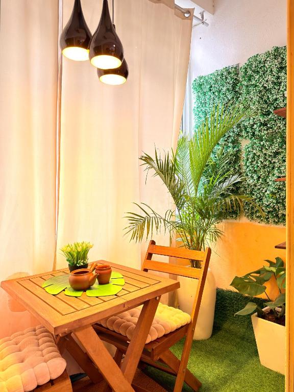 a wooden table and chairs in a room with plants at Cozy & Secure 1BR Apartment in Central Luanda in Luanda