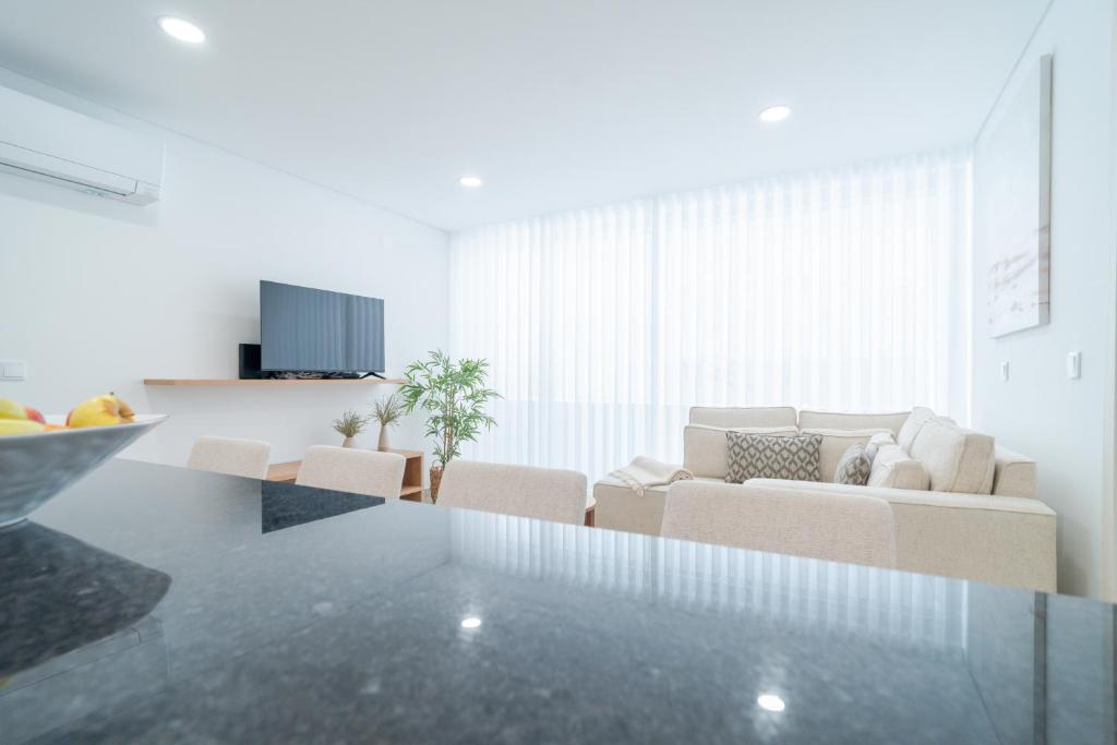 a white living room with a couch and chairs at Nina da Nazare in Nazaré