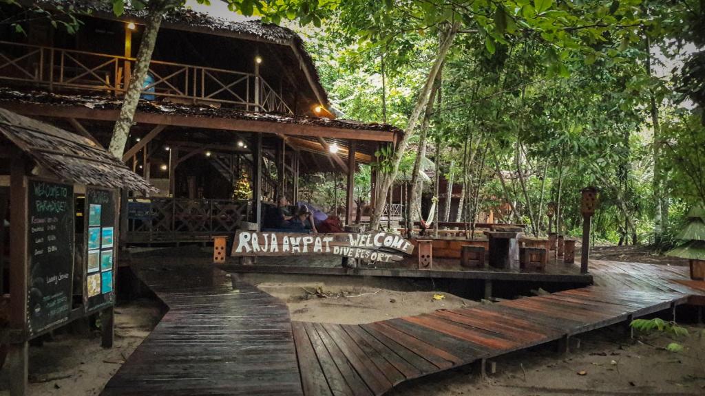 una terraza de madera frente a un edificio con árboles en Raja Ampat Dive Resort en Tapokreng