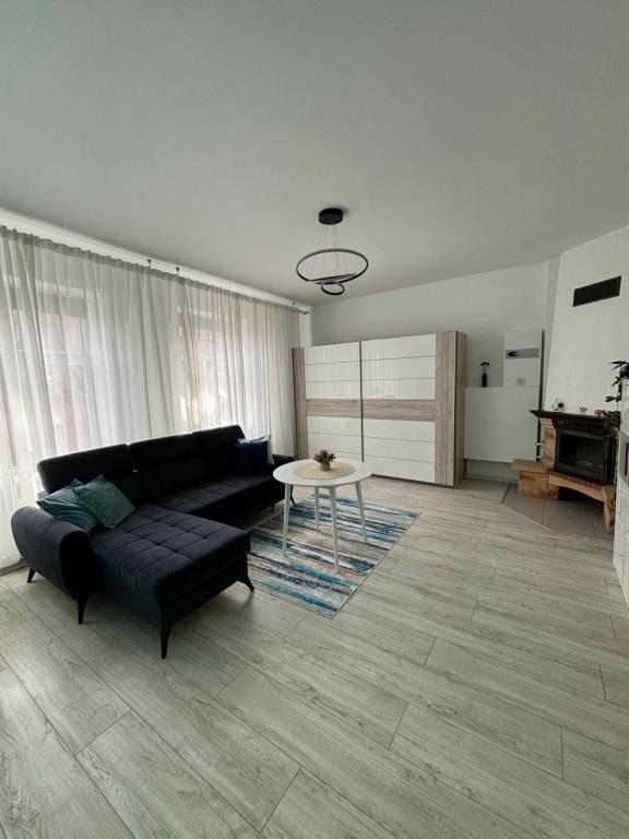 a living room with a black couch and a table at Vecpilsētas apartaments in Cēsis