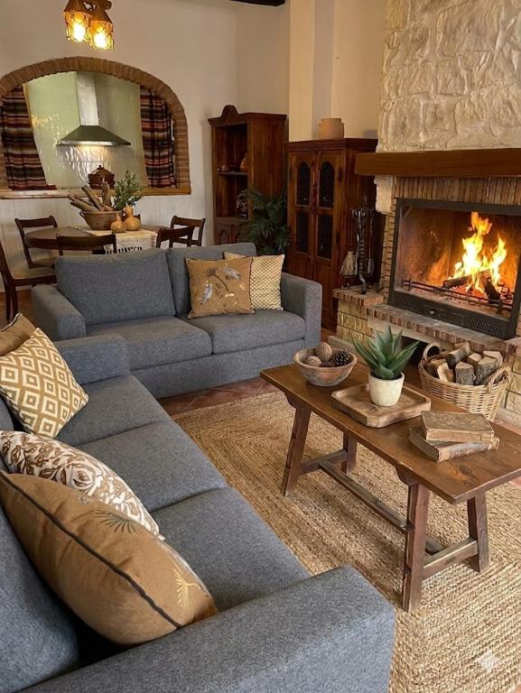 a living room with a couch and a fireplace at Casa Rural con Encanto Chimenea y Parking in Güéjar-Sierra