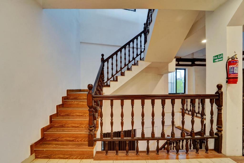 a staircase in a house with wood treads at Collection O Calvathy Road Near Fort Kochi in Cochin