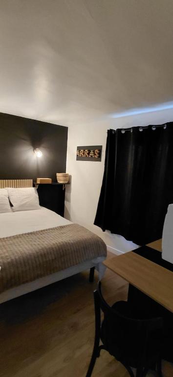 a bedroom with a bed and a table and a window at Le Désiré in Arras