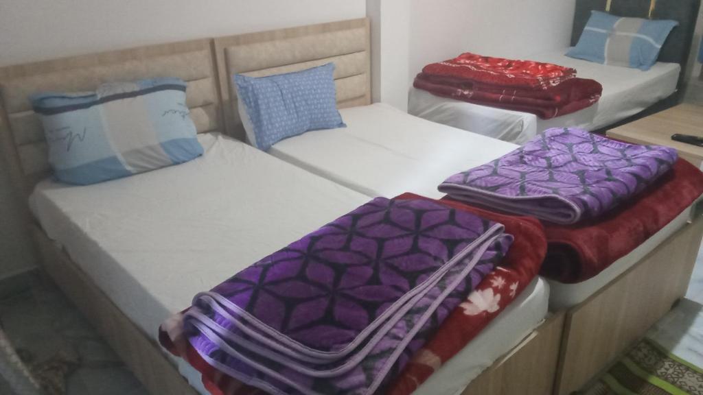 a group of three beds in a room at dar fatma matmata in Matmata