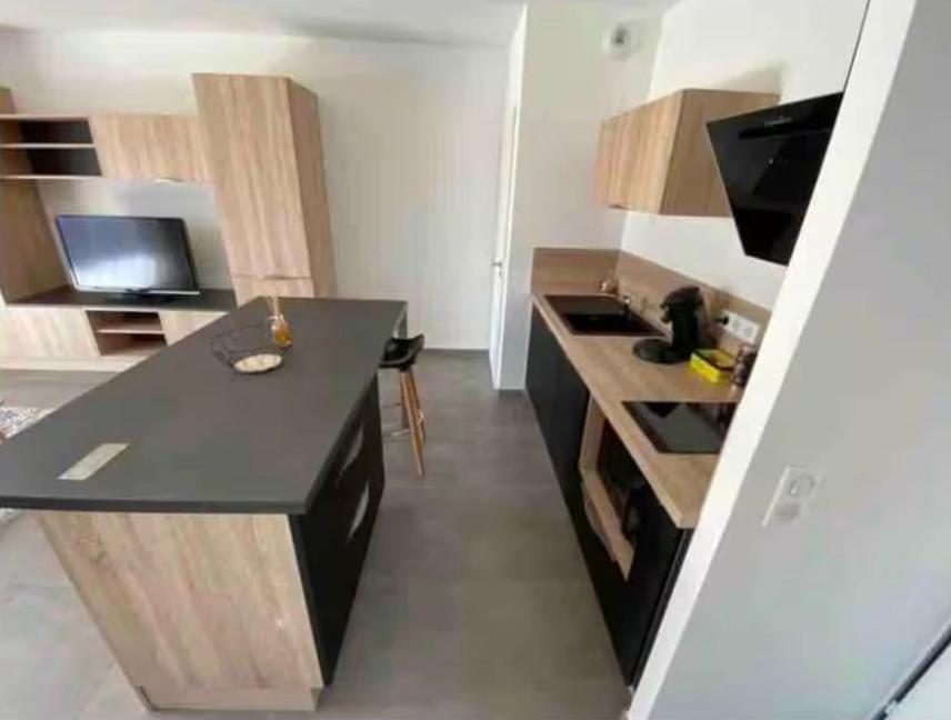 a kitchen with a black counter in a room at Grand Studio AFA in Afa