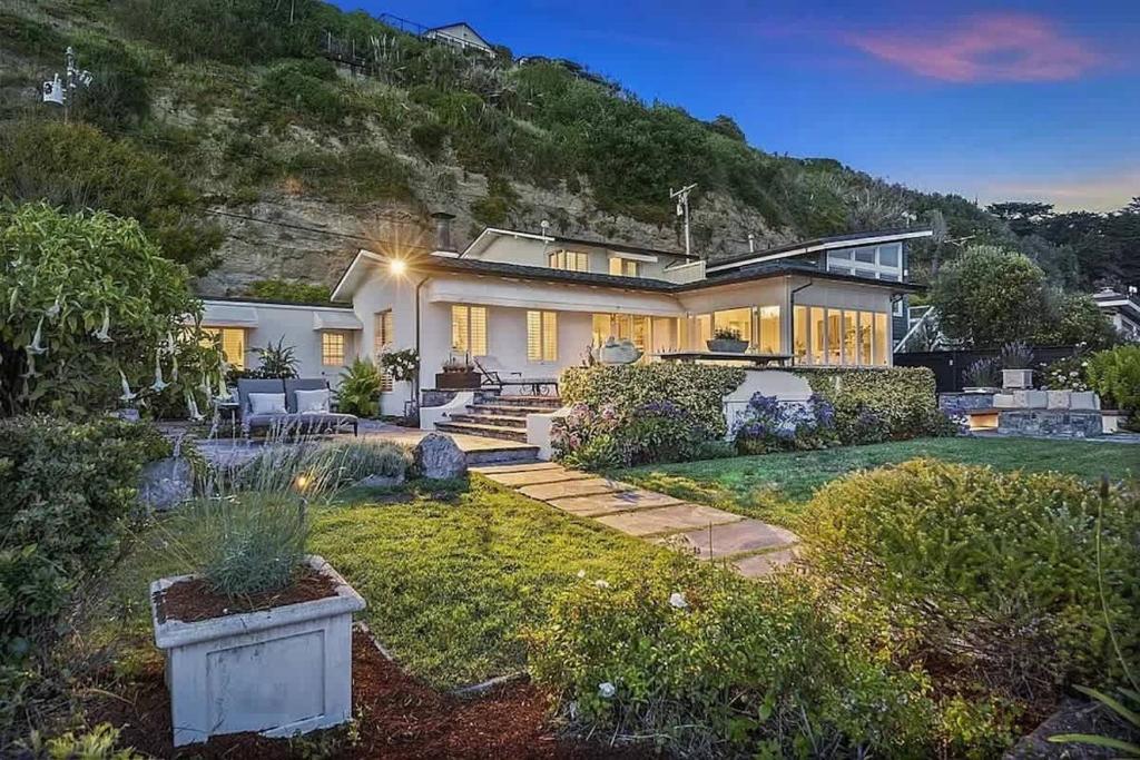 a home with a mountain in the background at Salty Sunrise in Aptos