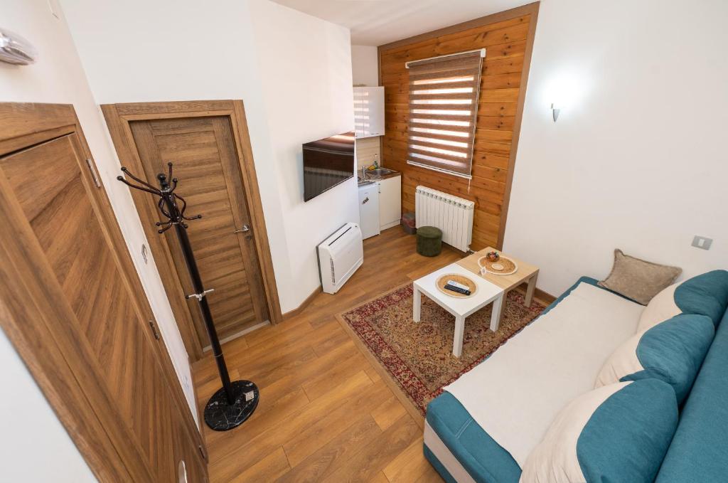a living room with a blue couch and a table at Apartmani Dino Kolasin in Kolašin