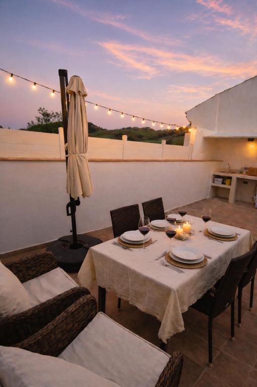 a dining room with a table and chairs and an umbrella at La Casita de Isabel, Near Ronda, Sierra de Grazalema in Montecorto