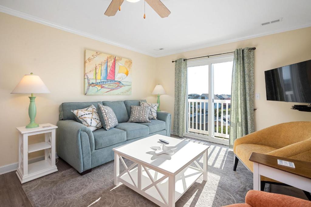 a living room with a couch and a tv at The Island Sandpiper by Oak Island Accommodations in Oak Island