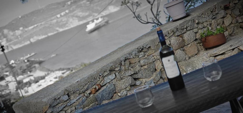 a bottle of wine sitting on a table with two glasses at ΜaryAnn`s house 2 in Livadakia