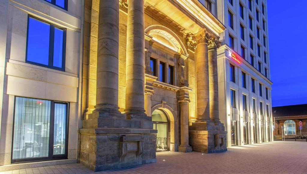 a large building with columns on a city street at Hilton Garden Inn Mannheim in Mannheim