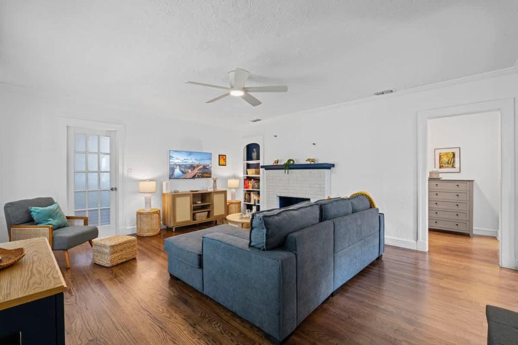 a living room with a blue couch and a ceiling fan at Belote Place Bungalow in Jacksonville