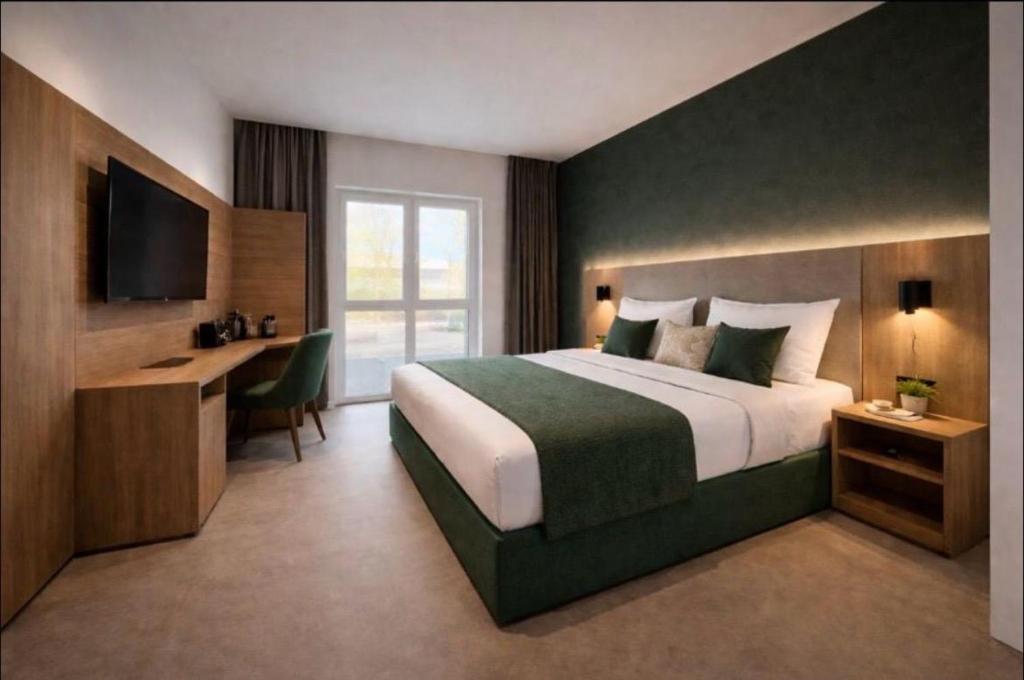 a bedroom with a bed and a desk and a television at Hotel Ks in Bad Fallingbostel