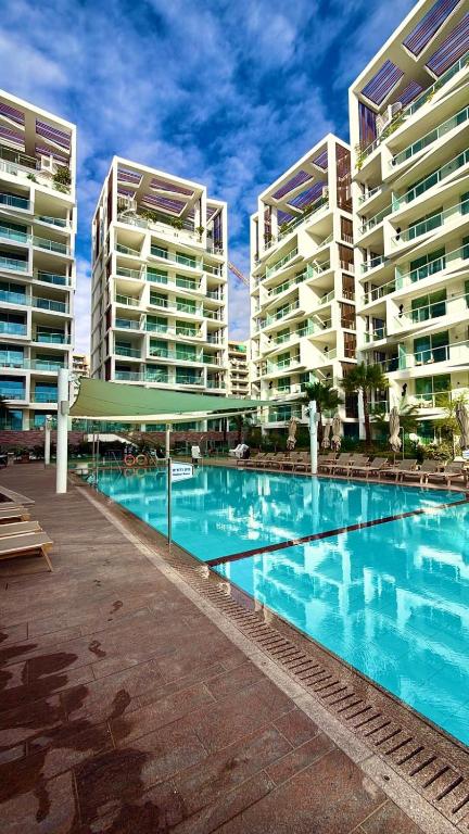 a swimming pool in front of two tall buildings at Redsearent front Pool and mountain View in Eilat