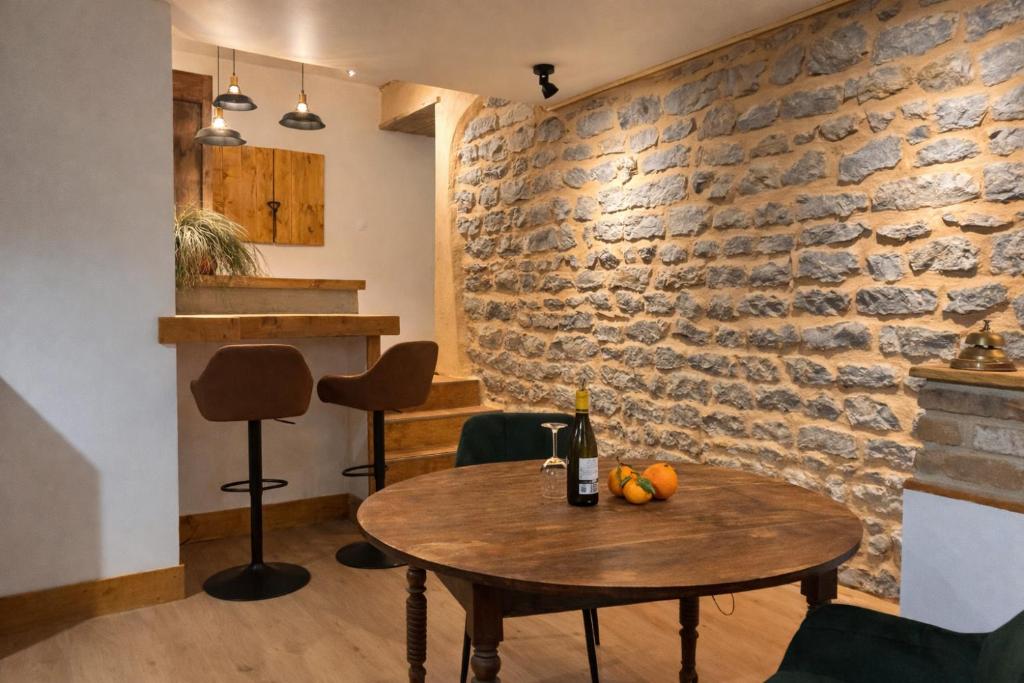 a table in a room with a brick wall at Le Roche-Velours in Paray-le-Monial