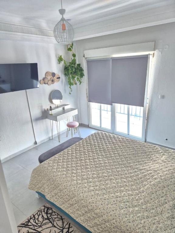 a bedroom with a bed and a table and a window at Mok's House in Kavála