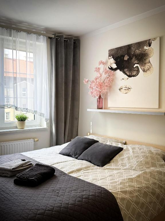 a bedroom with a bed and a window at Apartament Orange Piastowska in Ostróda