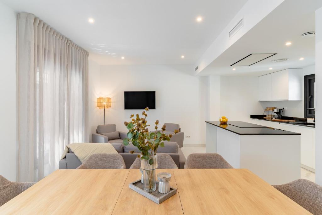 a living room with a dining table and a kitchen at Los Naranjos House in Marbella