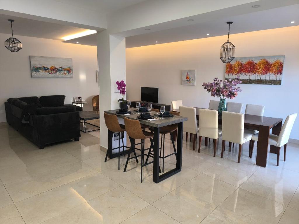 a dining room and living room with a table and chairs at Eva Luxury Apartment in Paphos