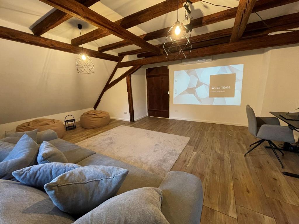 a living room with a couch and a projection screen at DenkMal Auszeit in Waibstadt