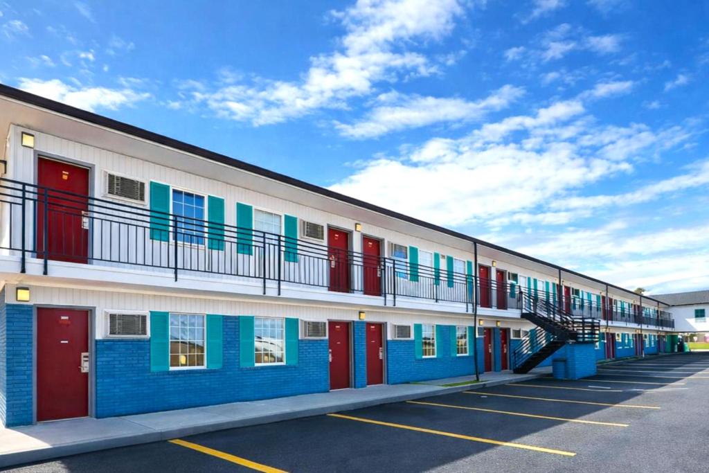 a building with colorful doors andwindows on a parking lot at Briarwood Motel Near Valdosta University I 75 in Valdosta