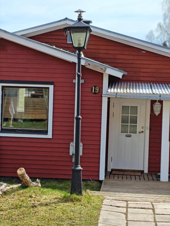 a red house with a street light in front of it at Familjenest in Bollnäs