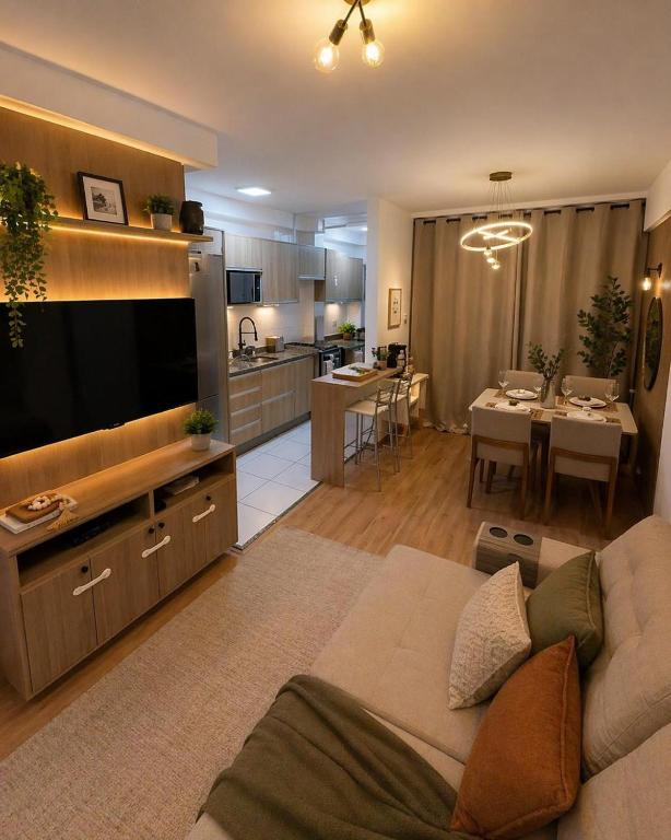 a living room with a couch and a large television at Recanto Augusta in Londrina