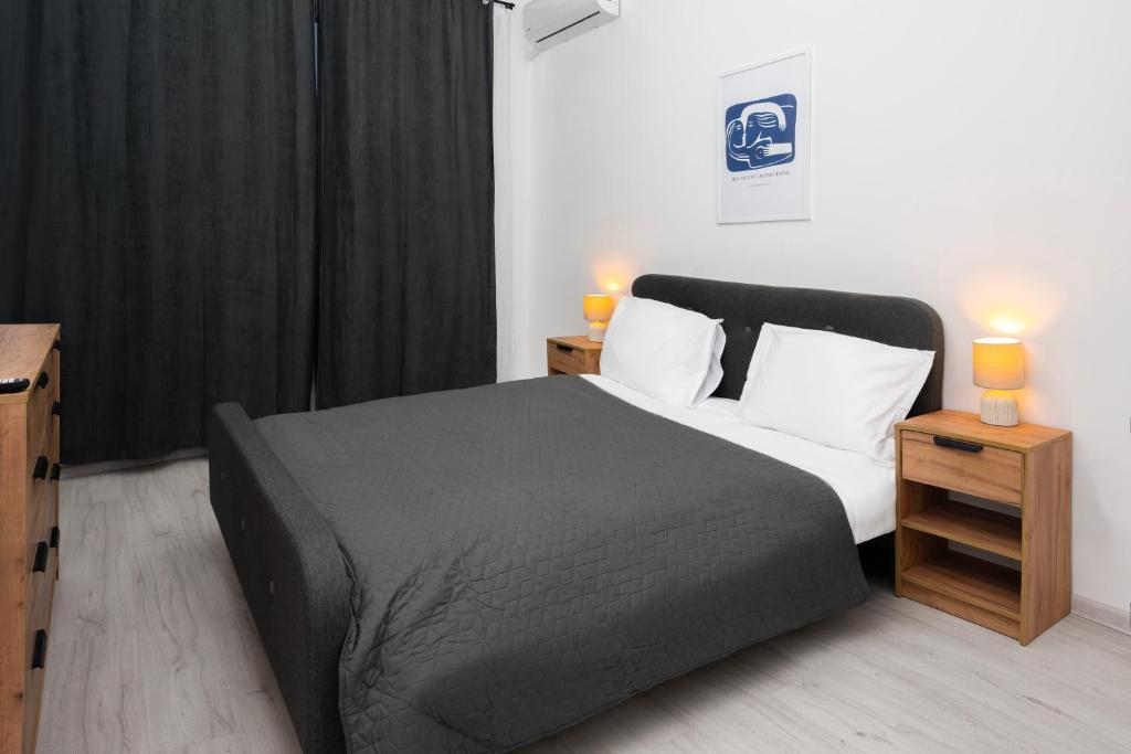 a bedroom with a bed with two night stands and two lamps at Escape Studio 4 Pollux Militari in Chiajna