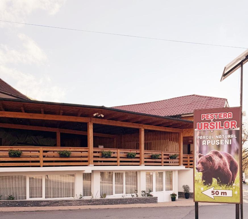 a building with a sign in front of it at Pensiunea Laura in Chişcău