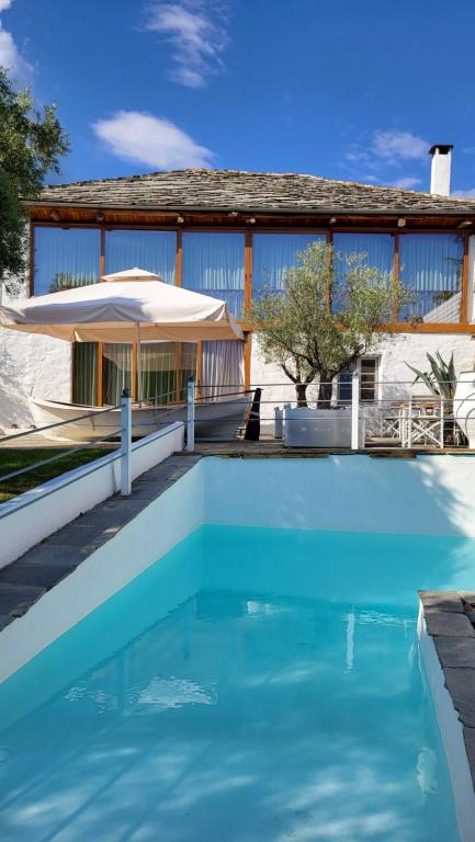 a blue swimming pool in front of a house at Villa Domatia in Kavála