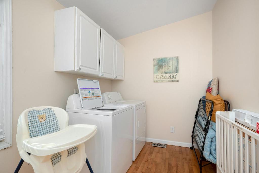 a white laundry room with a washer and dryer at This Is It by Oak Island Accommodations in Oak Island