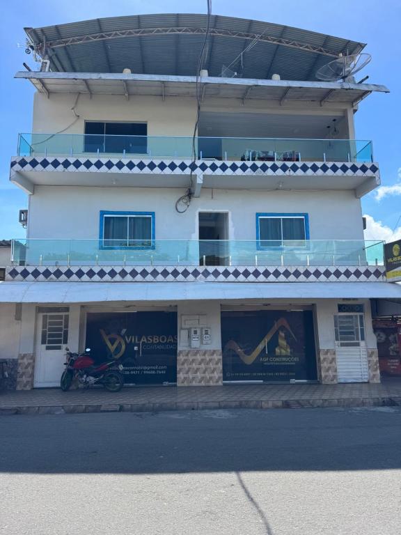 a building with a motorcycle parked in front of it at Pousada Vilasboas in Parintins