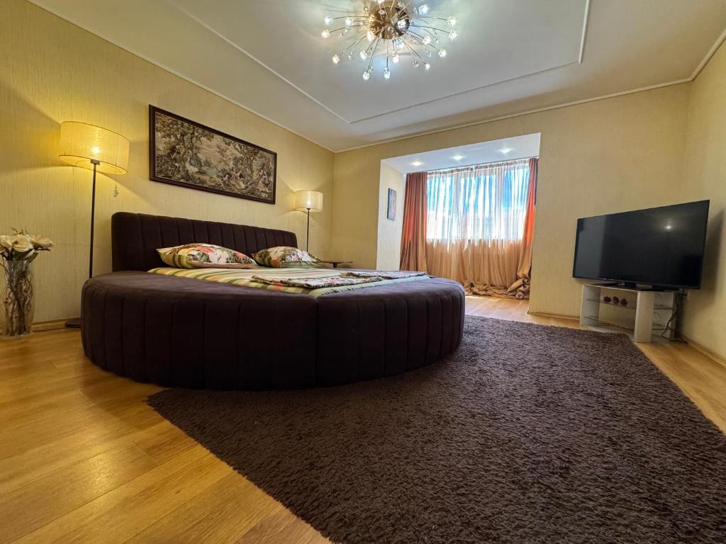 a bedroom with a large bed and a television at One bedroom king size center in Dnipro