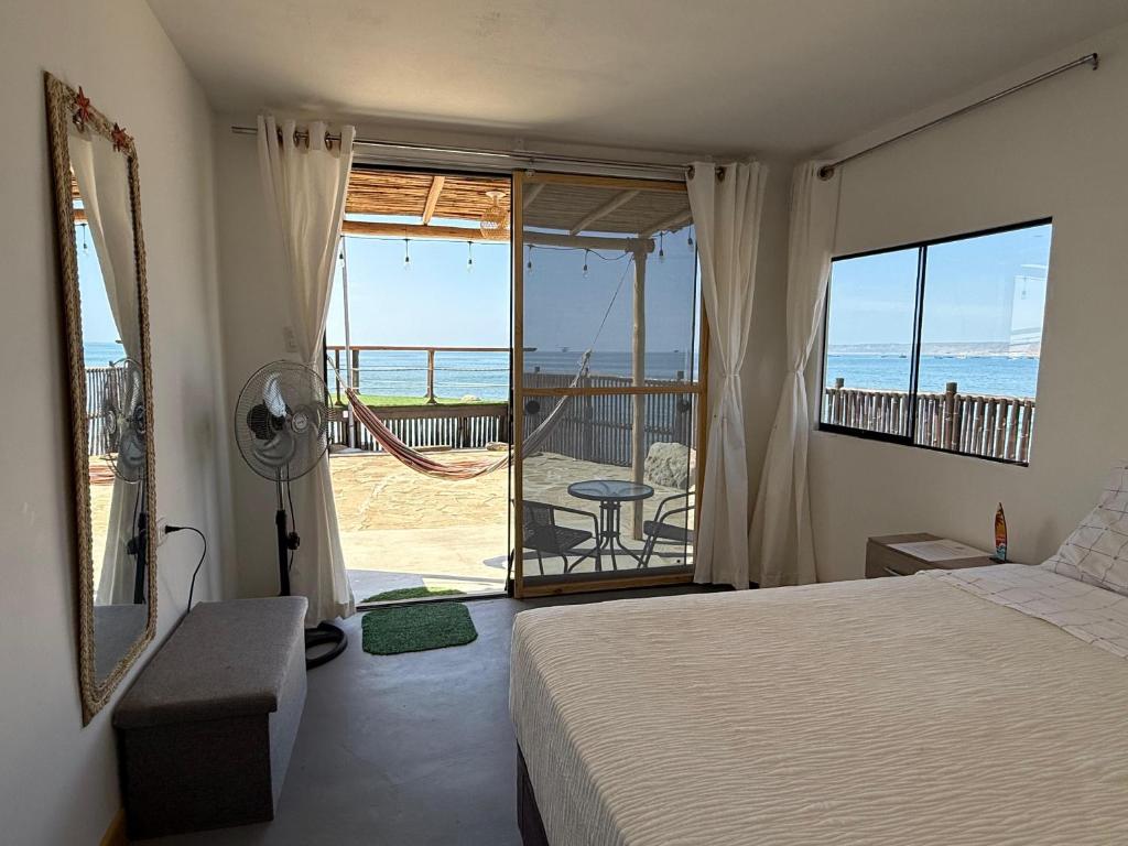 a bedroom with a bed and a view of the ocean at Surf & Sand Lobitos in Lobitos