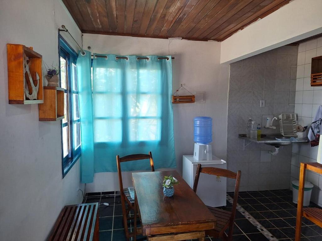 a dining room with a table and a blue curtain at Chalet da Bela Vista in Itamaracá