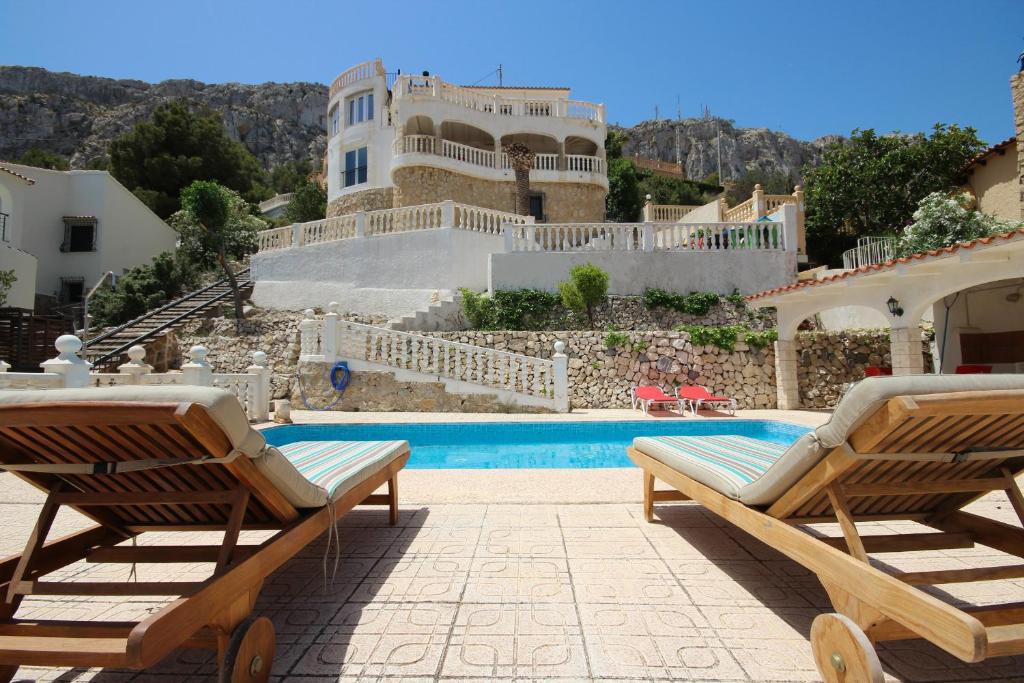 una piscina con 2 tumbonas y una casa en MAR23J en La Canuta