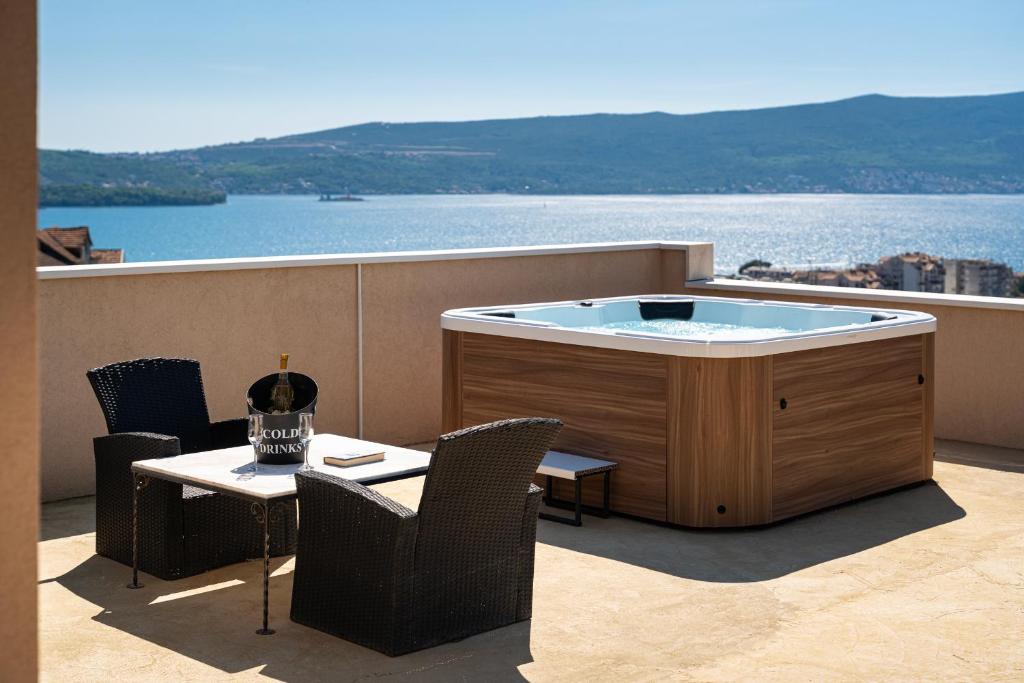a hot tub on a balcony with a view of the water at Adriatic Nest Residence in Tivat