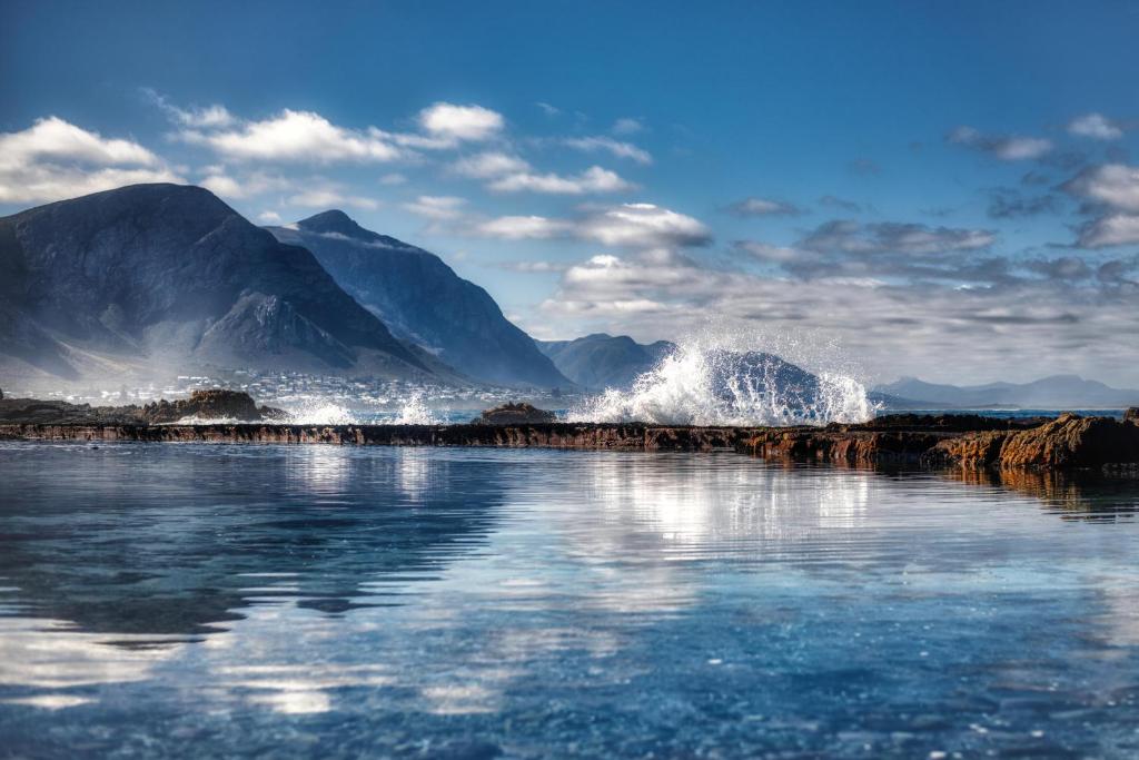 a body of water with mountains in the background at Walk Waterfront CliffPath Fireplace Secure-Parking in Hermanus