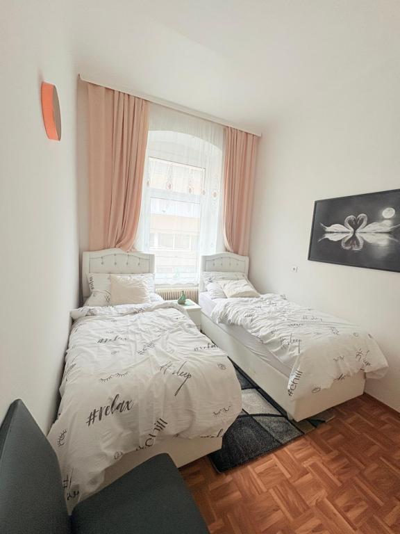 two beds in a room with a window at Beenie 17 in Linz