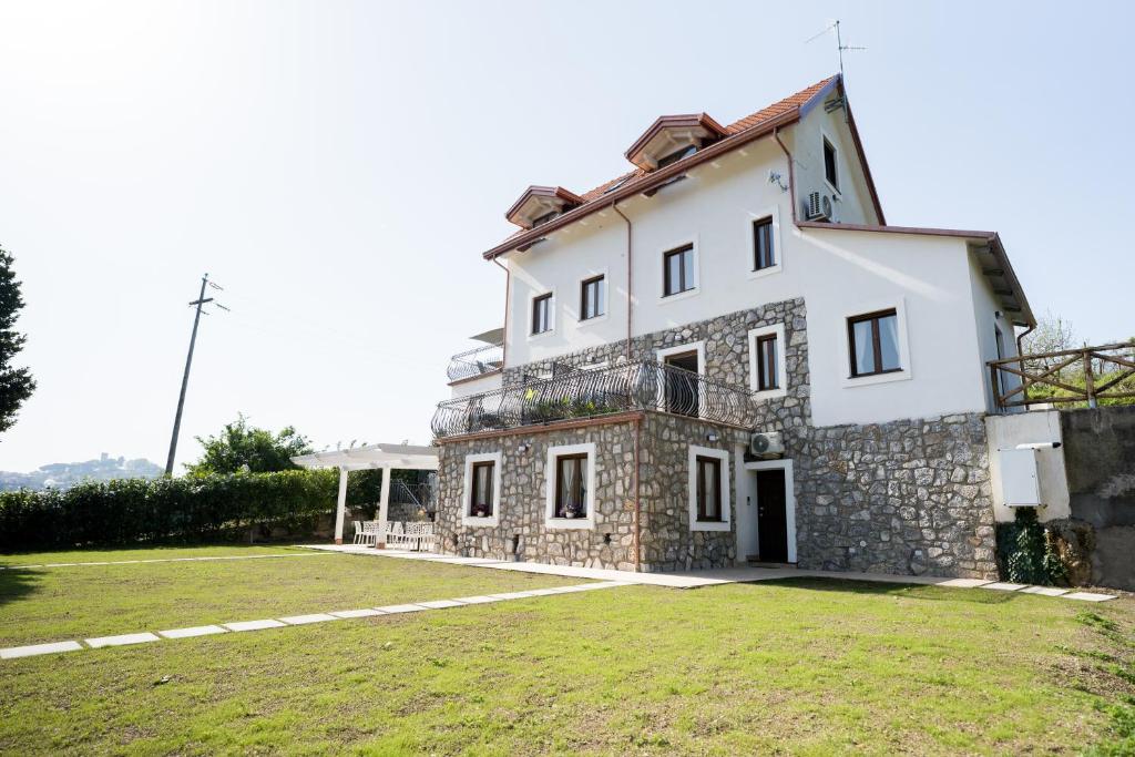 a large white house with a grass yard at Villa Rossa in Agerola