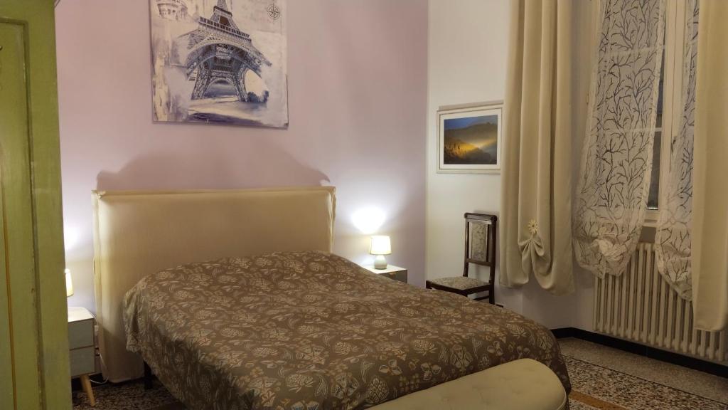a bedroom with a bed and a picture of the eiffel tower at Contessa Alba in Savona