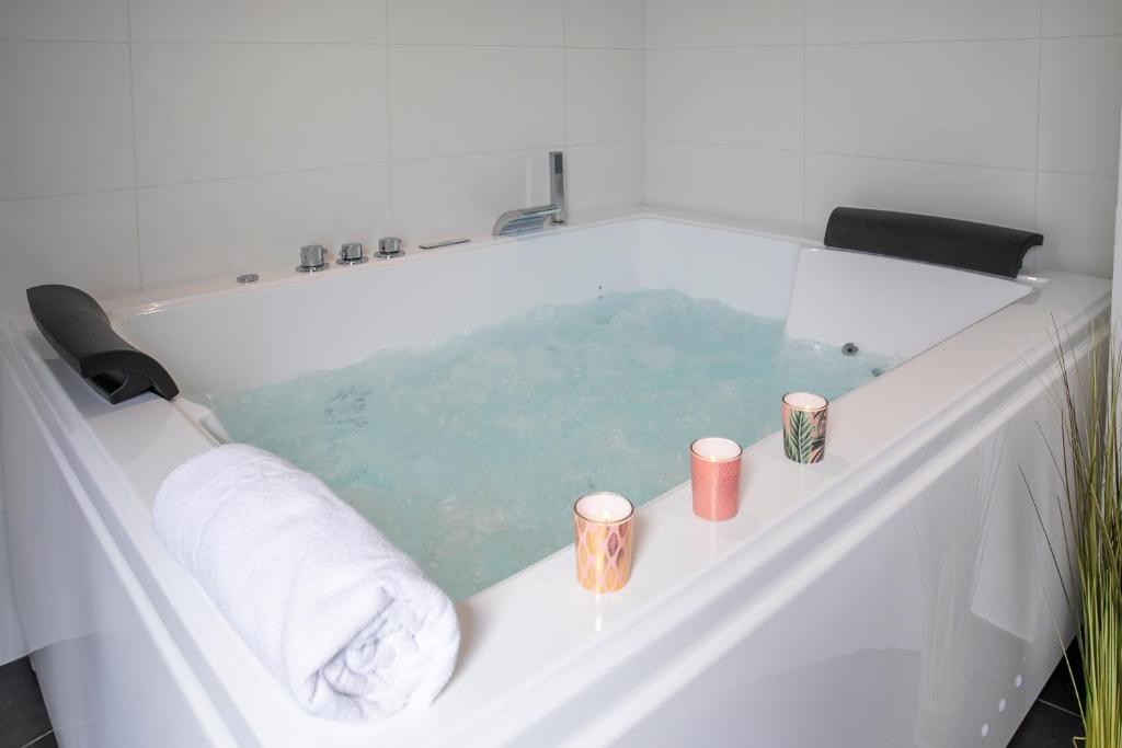 a bath tub filled with water with towels and candles at Chablis SPA Premier Cru in Chablis
