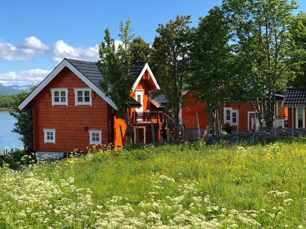 a wooden house on the shore of a lake at Aaroybukt Guesthouse in Årøybukta