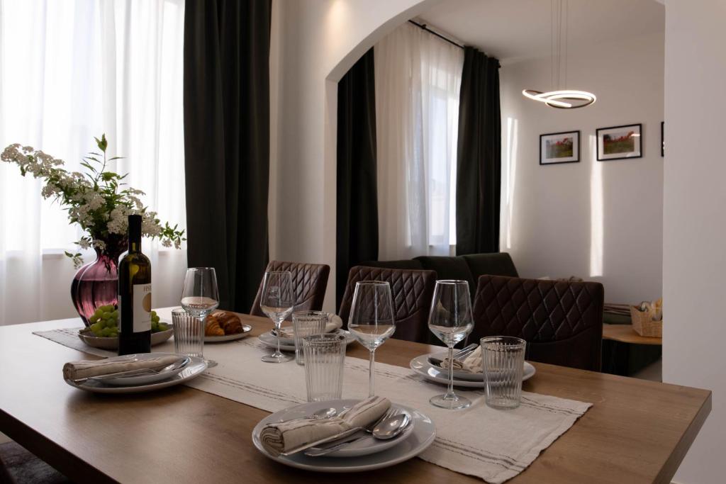 a dining room table with a bottle of wine and glasses at Lume Capi in Labin