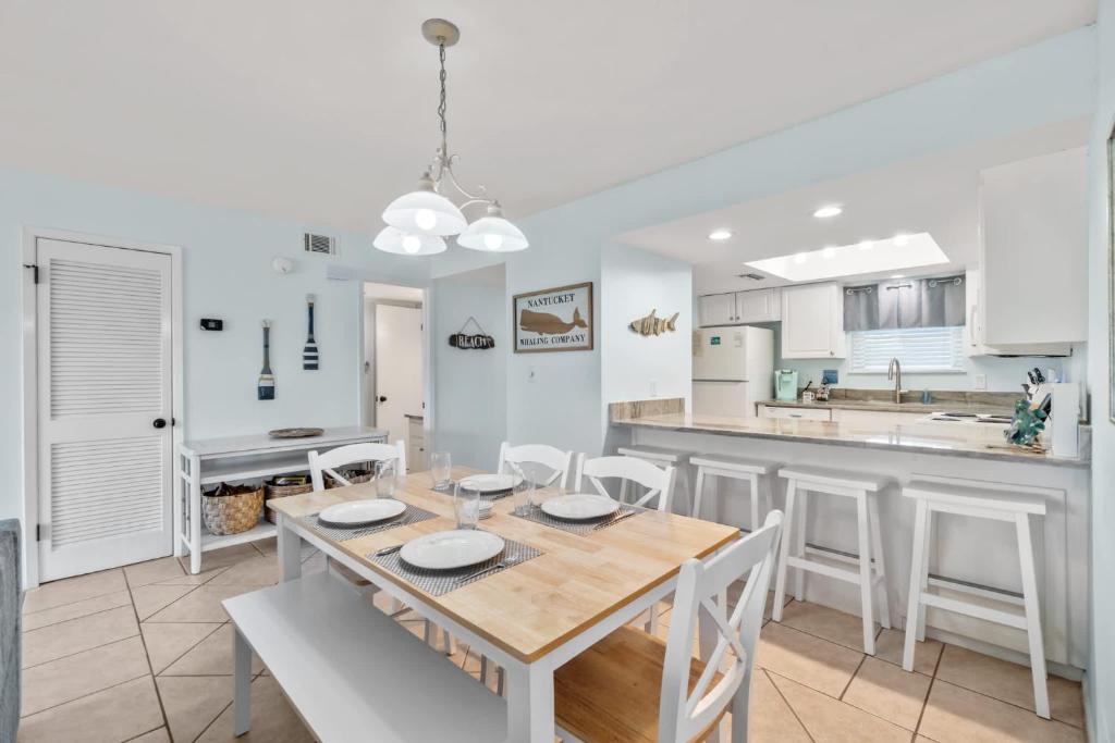 a kitchen and dining room with a table and chairs at Sand Between Stays in Orange Beach