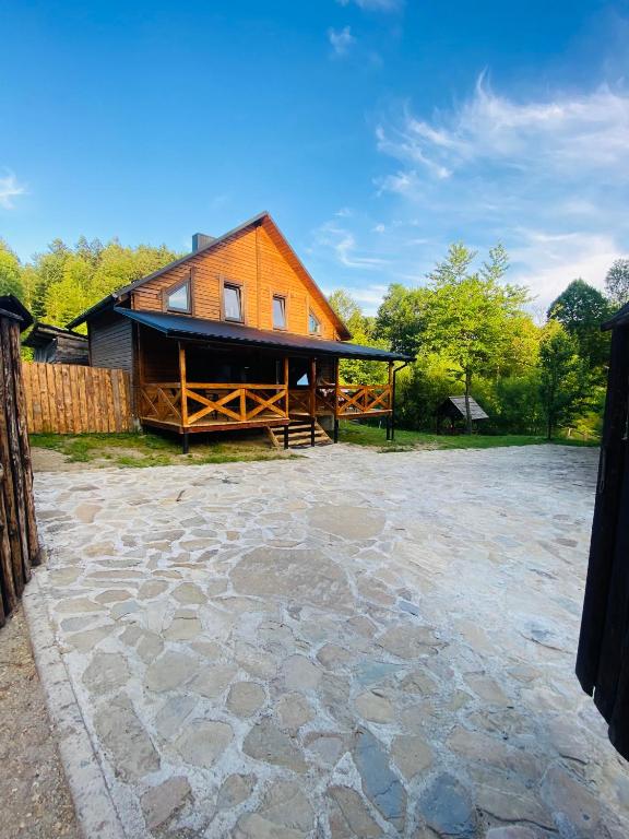 a barn with a stone patio in front of a house at Агрооселя Ростоки in Zhdanivka